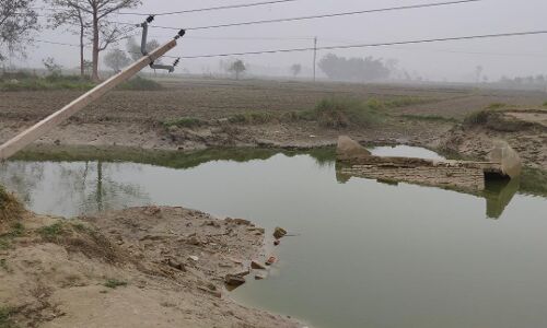 बाढ़ के महीनों बाद भी क्षतिग्रस्त सड़क की मरम्मत नहीं, किनारे लटके हैं बिजली के खंभे और तार