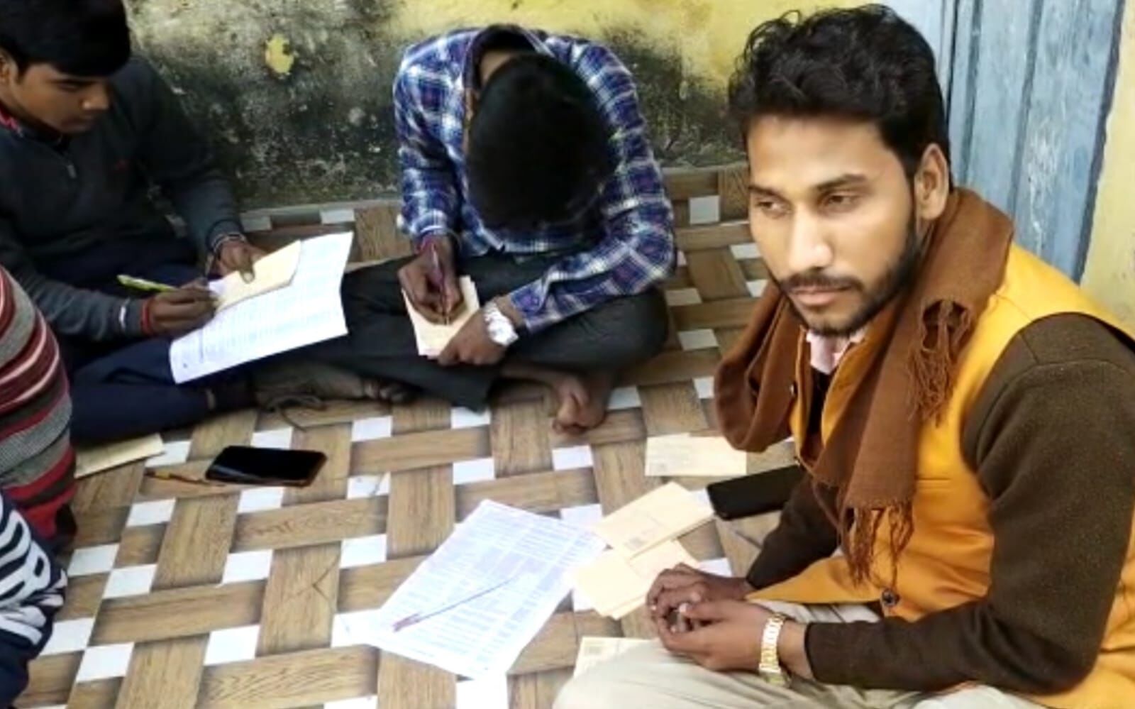 (पीलीभीत के विकासखंड बरखेड़ा कार्यालय परिसर में बैठकर लाभार्थियों की लिस्ट लेकर उनकी ओर से फर्जी धन्यवाद पत्र लिखने में जुटे पंचायत सहायक)