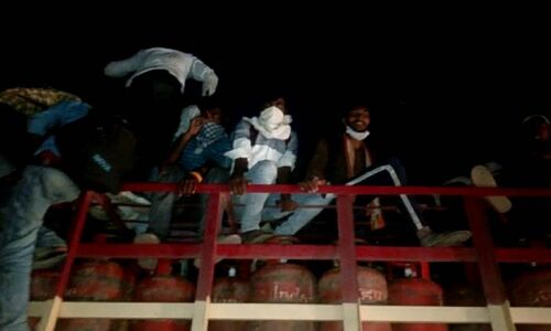 घर पहुंचने की जल्दी में गरीब-मजदूर सिलेंडर लदी गाड़ियों पर चढ़ने को मजबूर